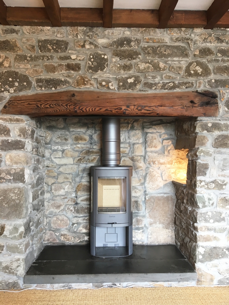 Contura 810 in a traditional stone fireplace