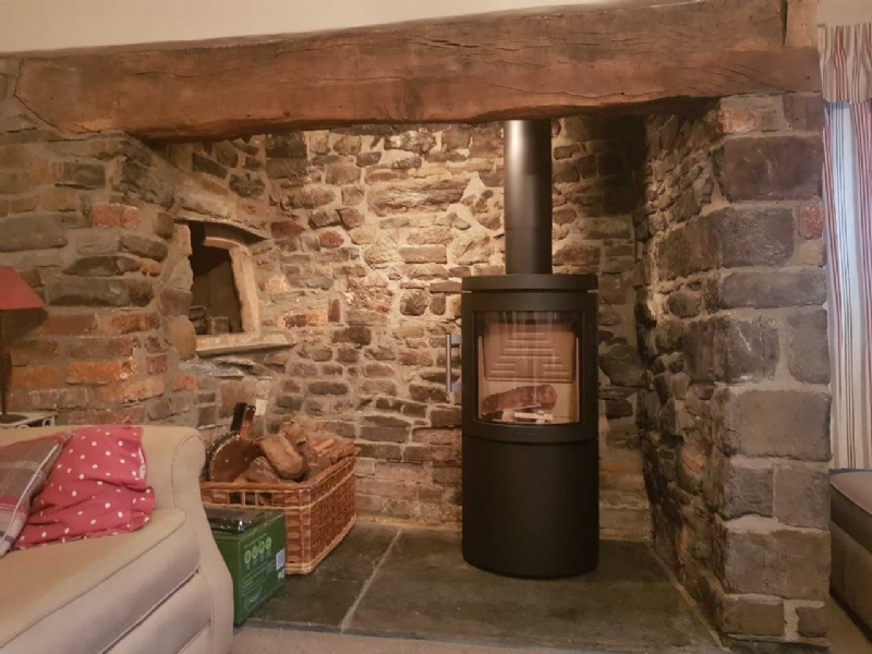 Hwam woodburner in a traditional fireplace in Cornwall
